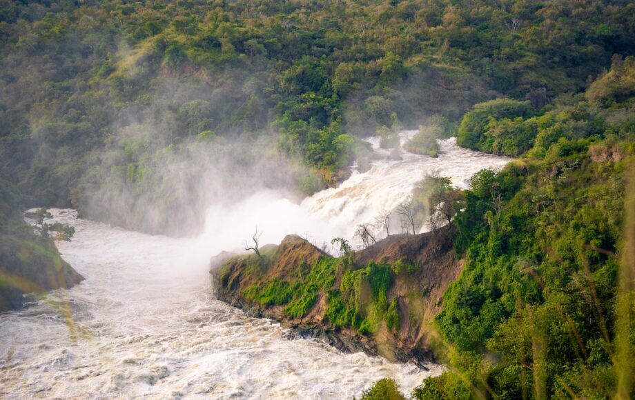 Het kolkende water van Murchison Falls dat tussen groene rotswanden in Oeganda stroomt.