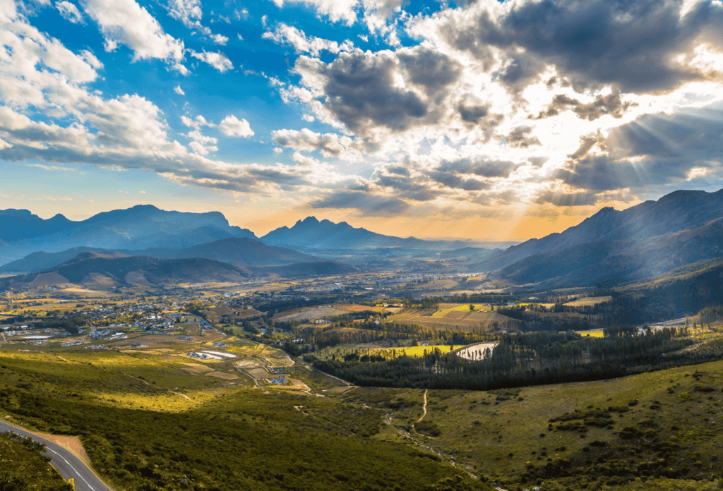 Glooiende wijnlanden van Franschhoek met wolken en stralen van de zon