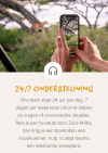 Resenär fotograferar ett lejon under en safari med information om support dygnet runt och nödnummer för bilresor i Sydafrika.