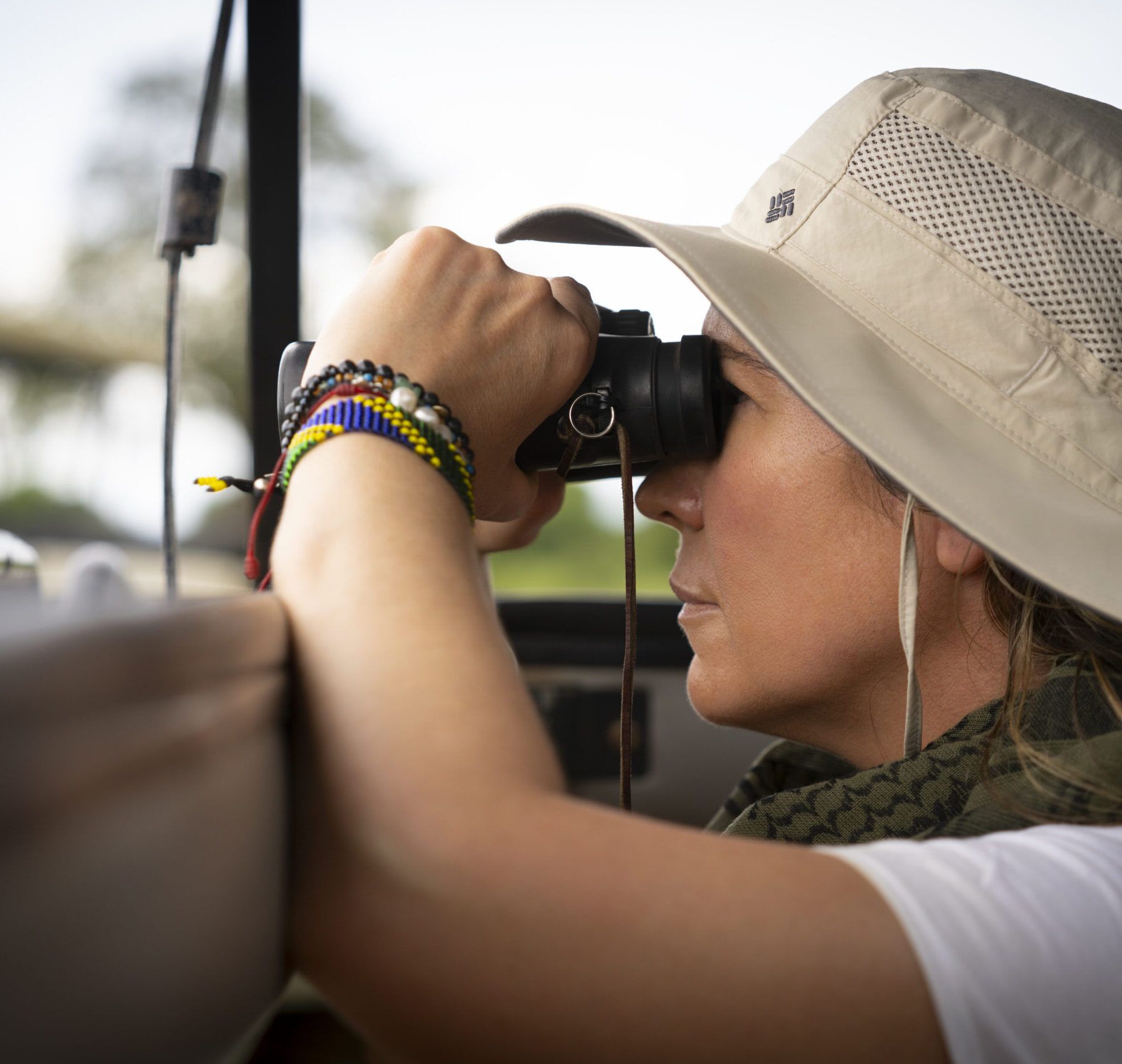 Vrouw met verrekijker in de Serengeti